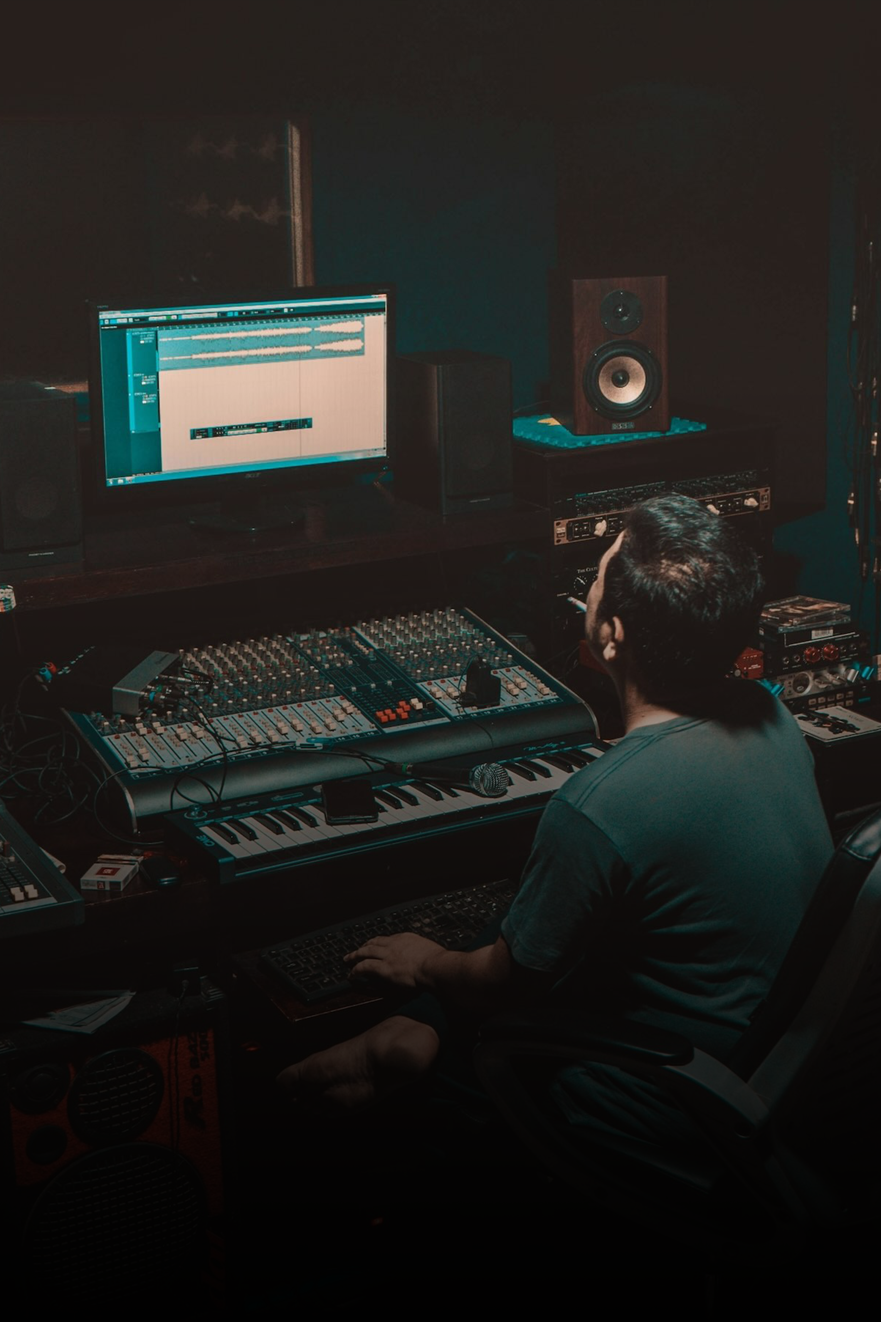 Image for the Production Music Tools Music Templates section. The image depicts a person working in a music studio with monitors and mixing equipment. Visible text on the image reads: "Templates Customized composing templates for your DAW Shop Now" with "Shop Now" as a button.