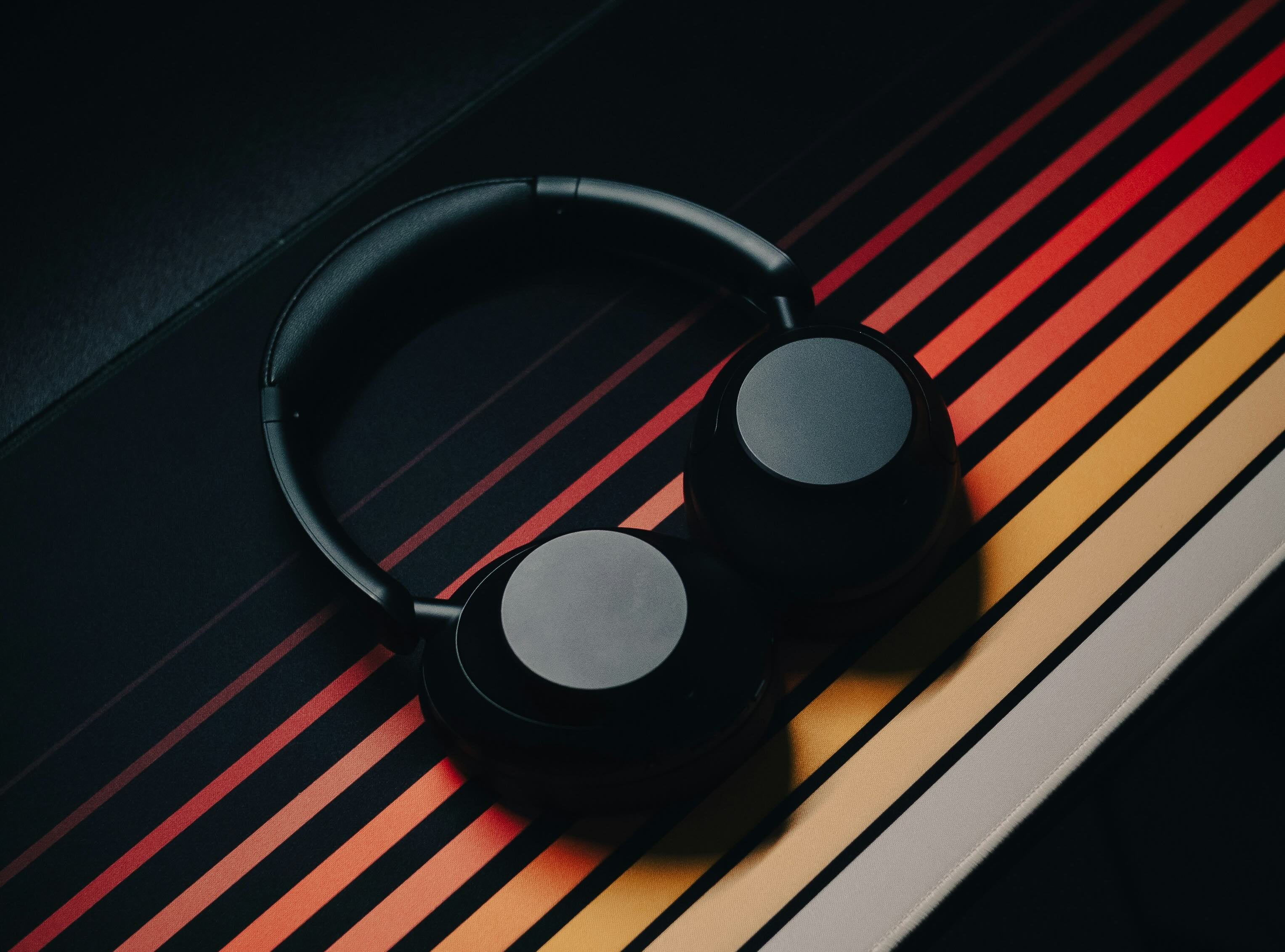 Image advertising a Production Music Tools promo code with text: "BUY 3 PRODUCTS OR MORE AND GET 15% OFF. PROMO CODE: 3TOOLS. *Promo can only be used once." The image features a pair of black headphones on a colorful striped background.